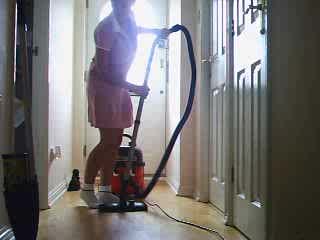 School girl vacuuming hallway