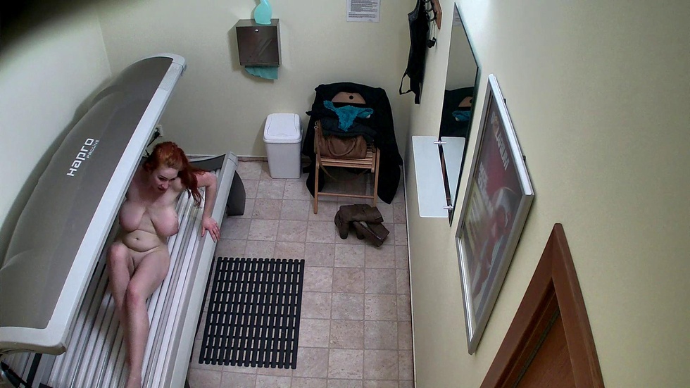 Busty redhead masturbates in solarium